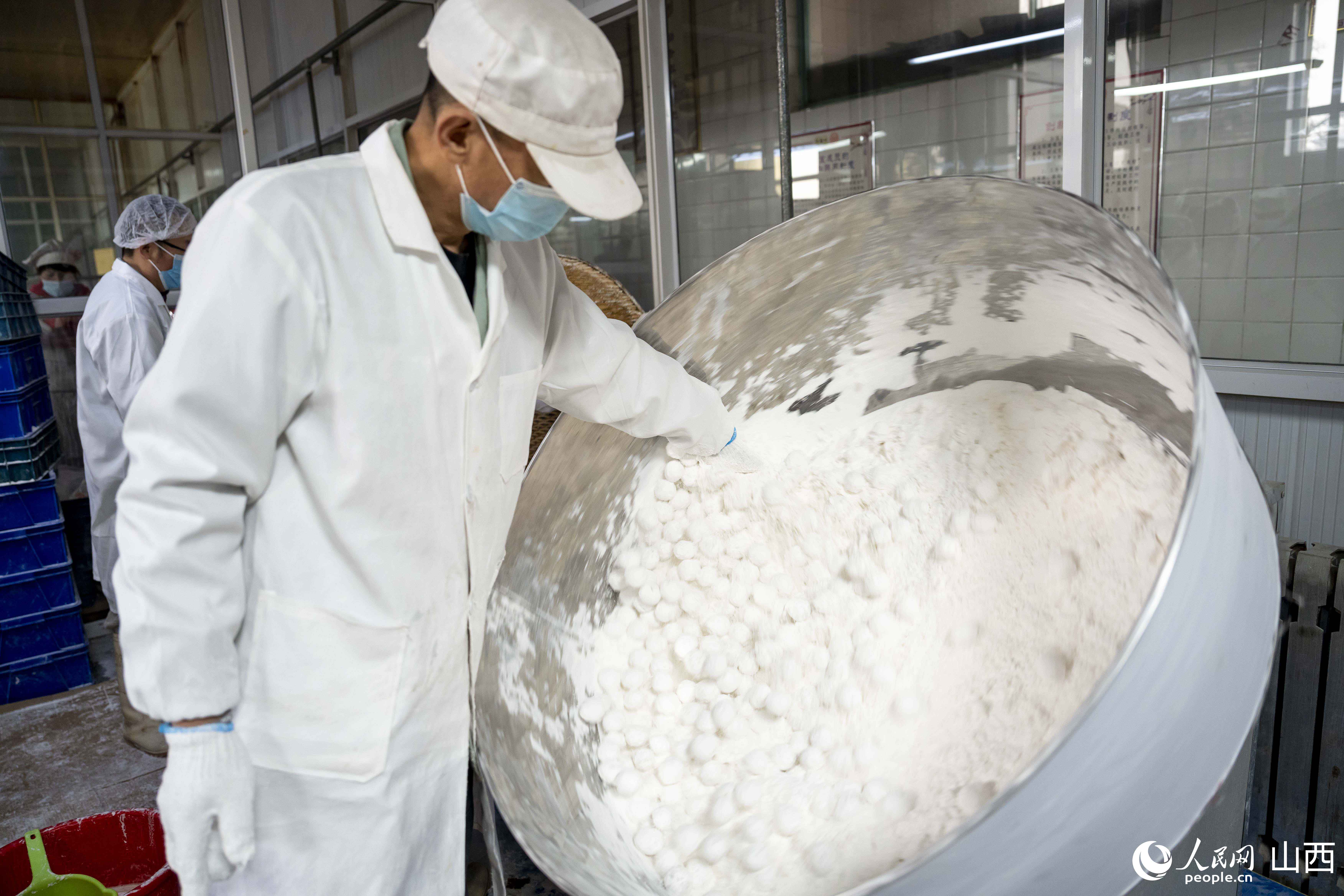 工人正忙著滾制元宵。人民網盧鵬宇?攝