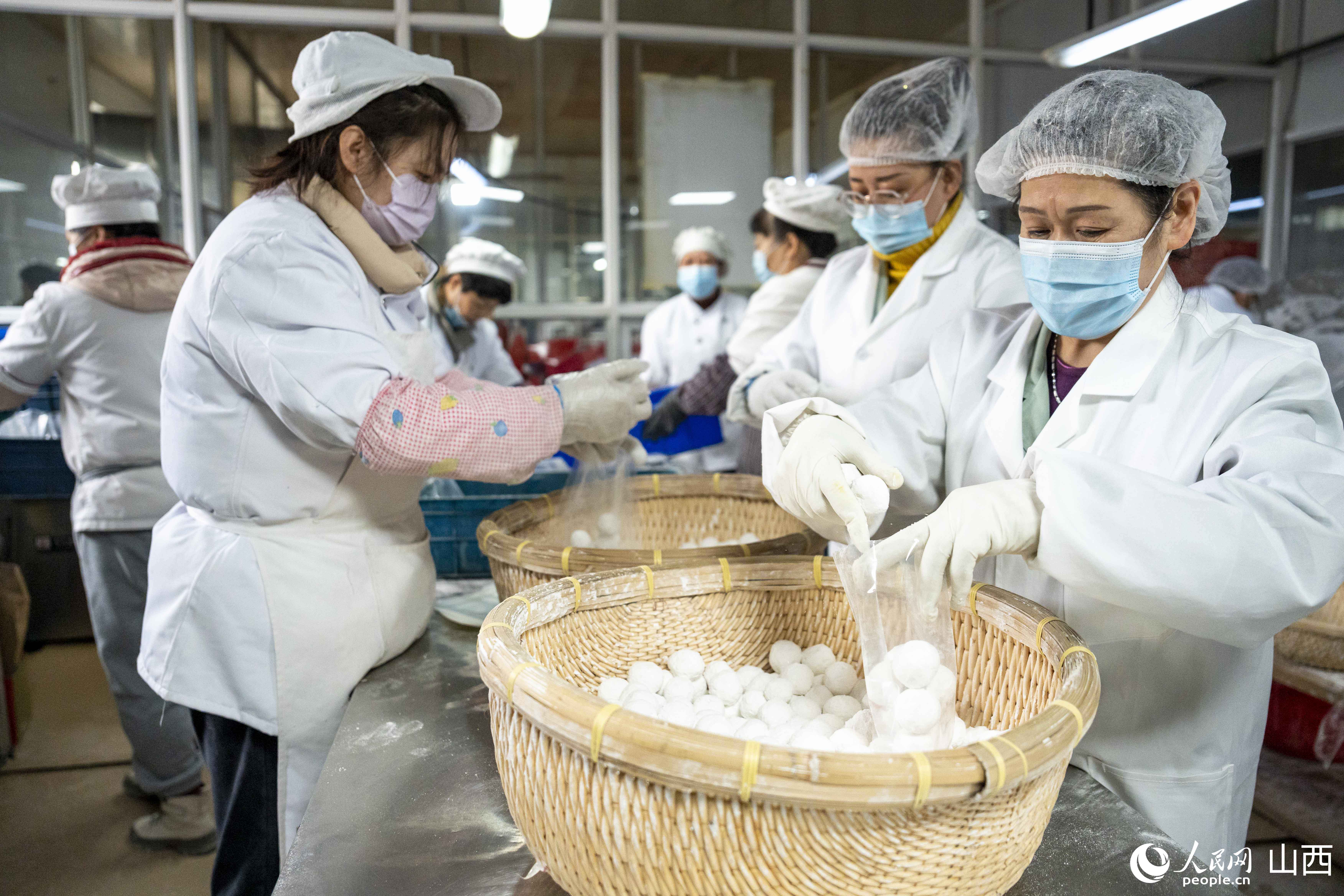 工人們正在分裝元宵。人民網盧鵬宇?攝