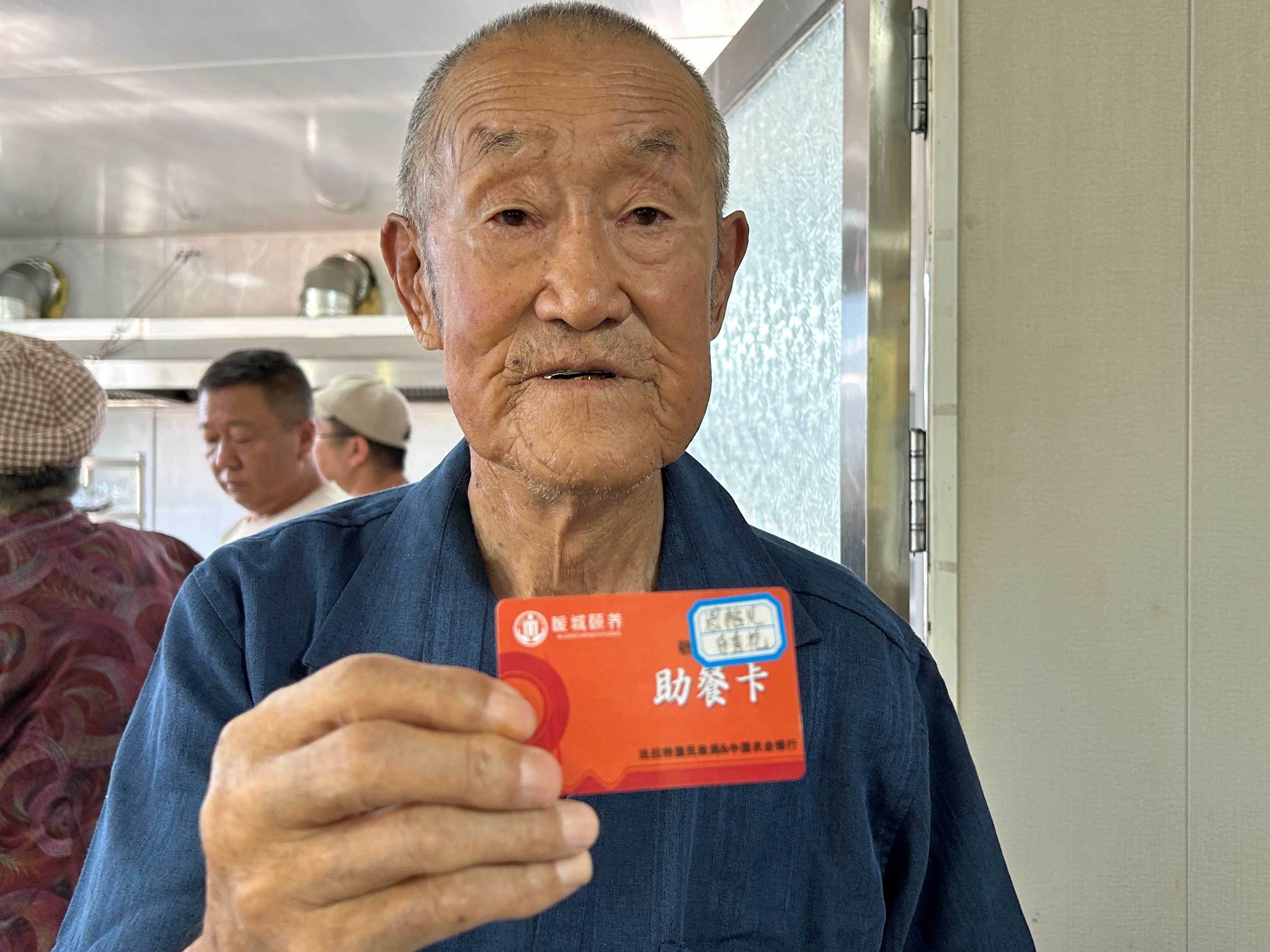周銀栓老人向記者展示老伴兒的助餐卡。人民網 鄭莉茵攝
