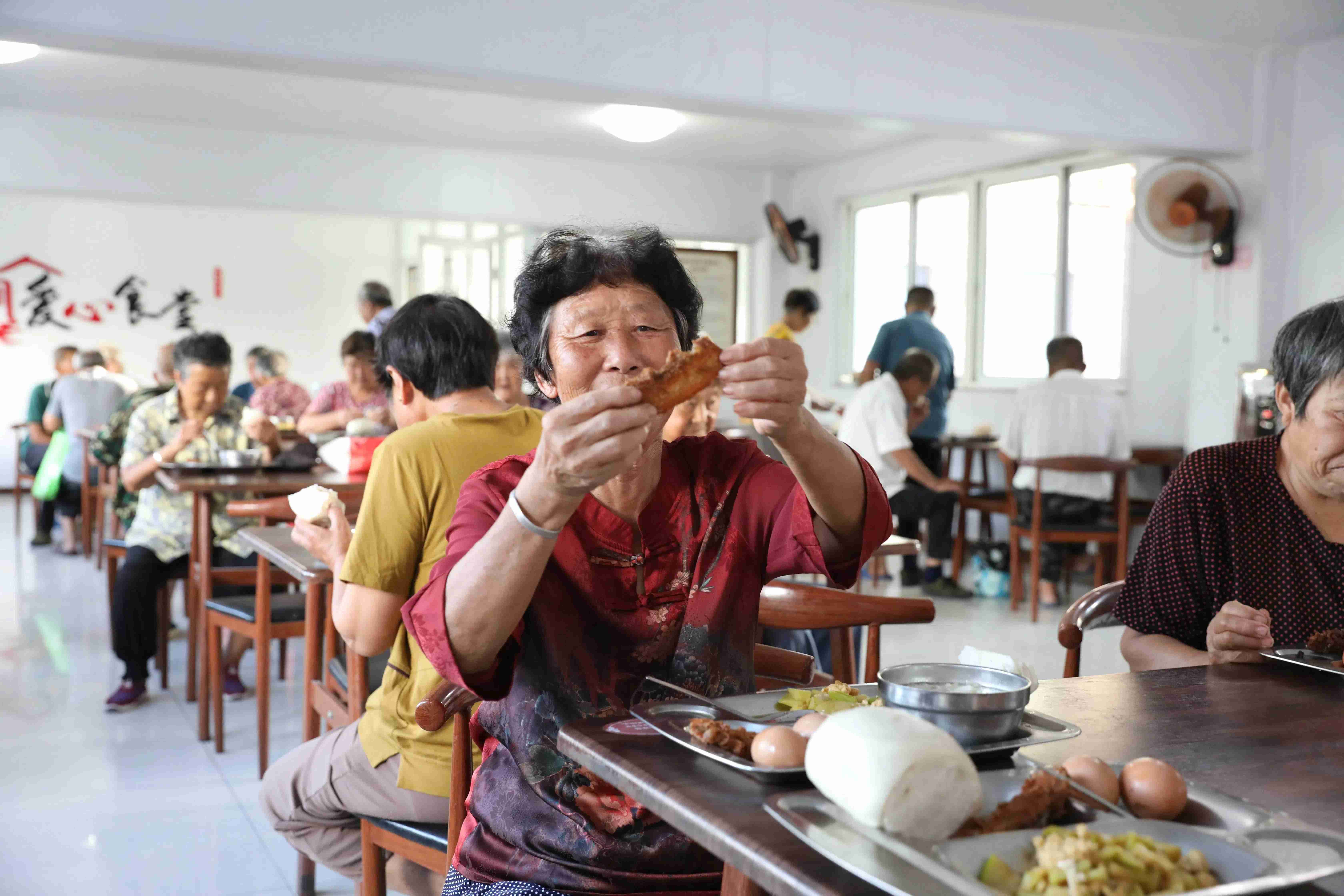 就餐老人向記者展示菜品。人民網記者 劉祺攝