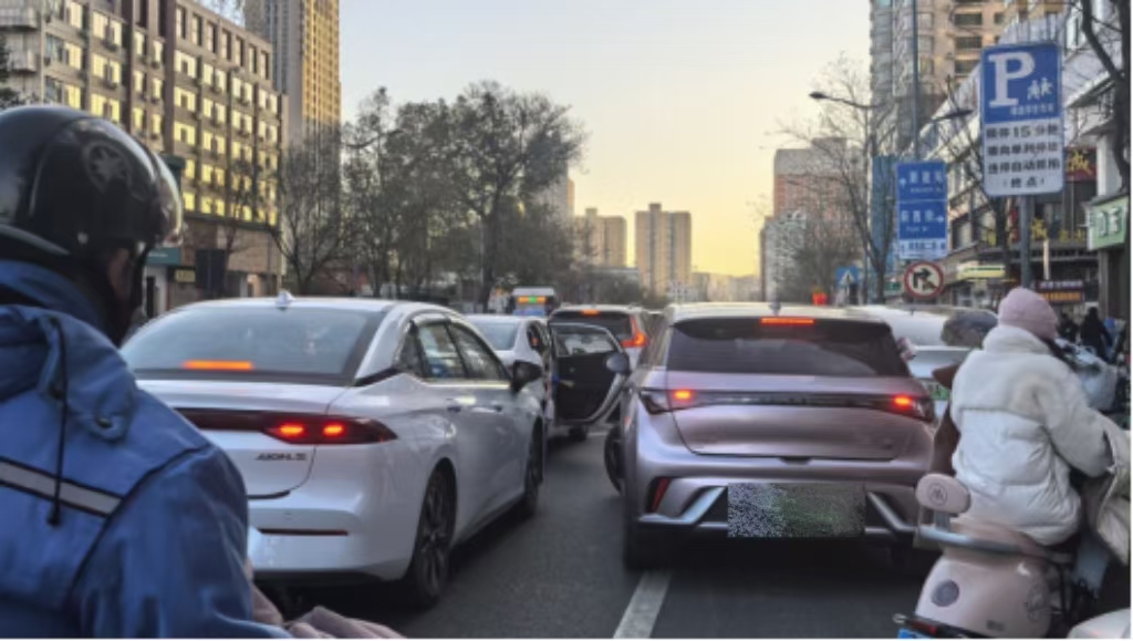 旱西關街旱西關南二條路口，送學車輛在直行車道停車下人。車門推開時，后方粉色車輛剛剛向左前方起步，險些發生磕碰。人民網記者王晏如攝