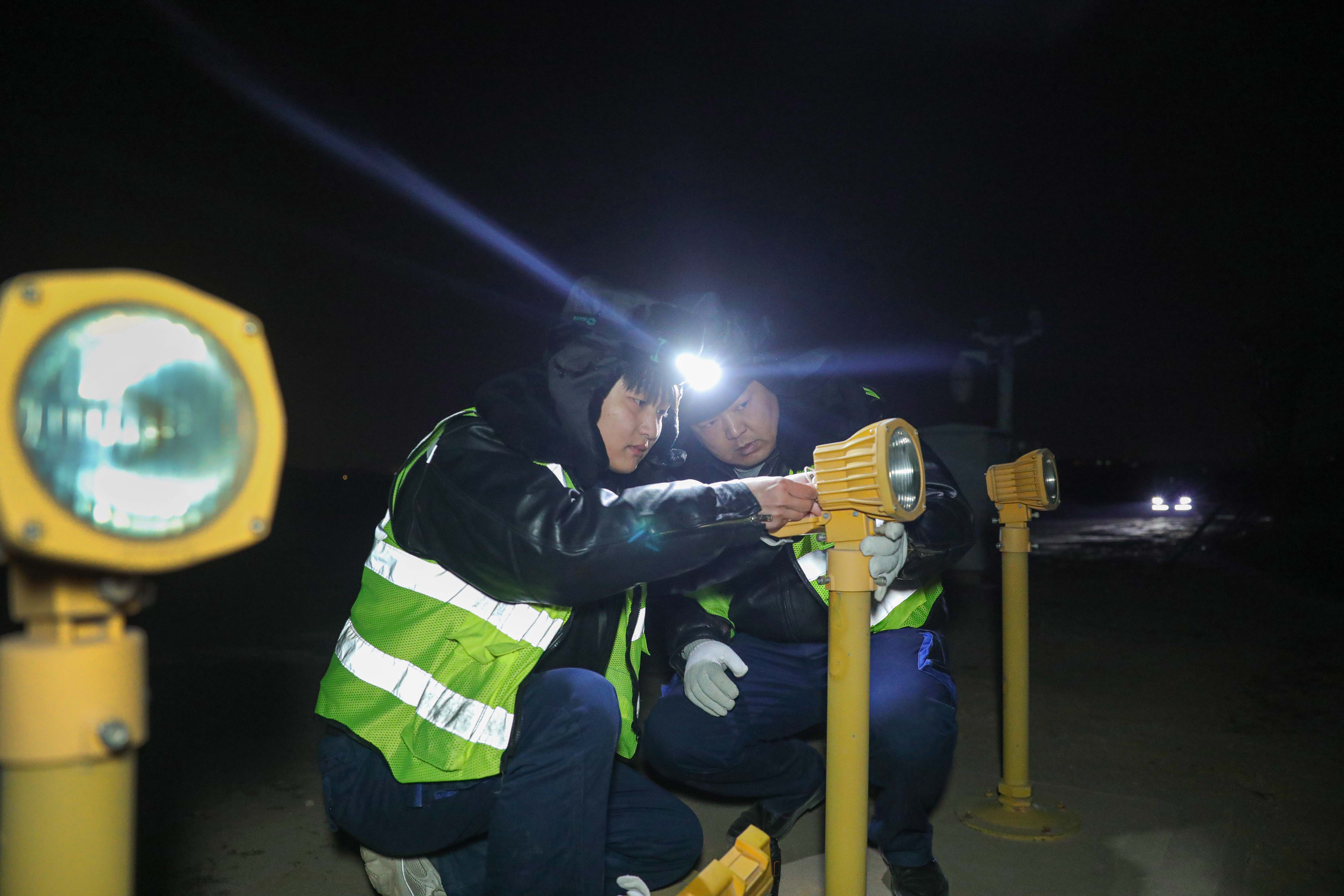 路偉和同事檢修故障燈具。