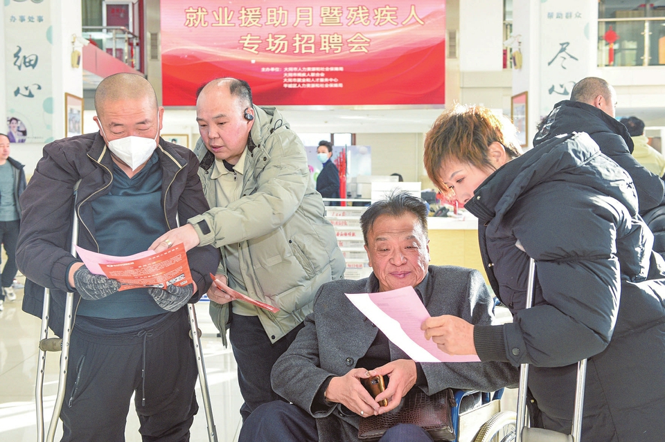 2025年就業援助月暨殘疾人專場招聘會在大同市就業創業服務中心舉行。圖為求職者正在詳細了解企業招聘信息。