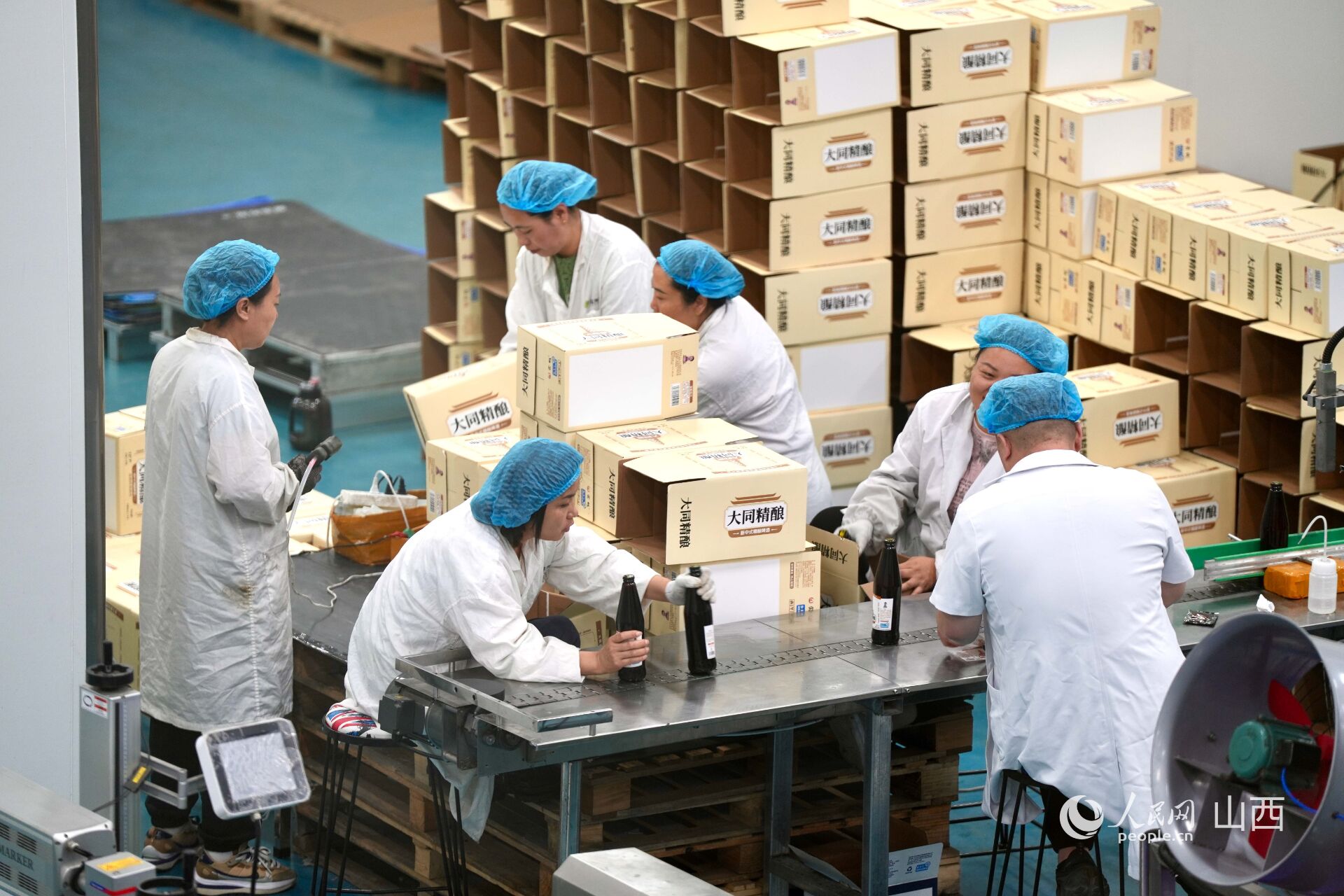 大同三利集團生產車間內，工人正在分裝黃花啤酒。人民網 盧鵬宇攝
