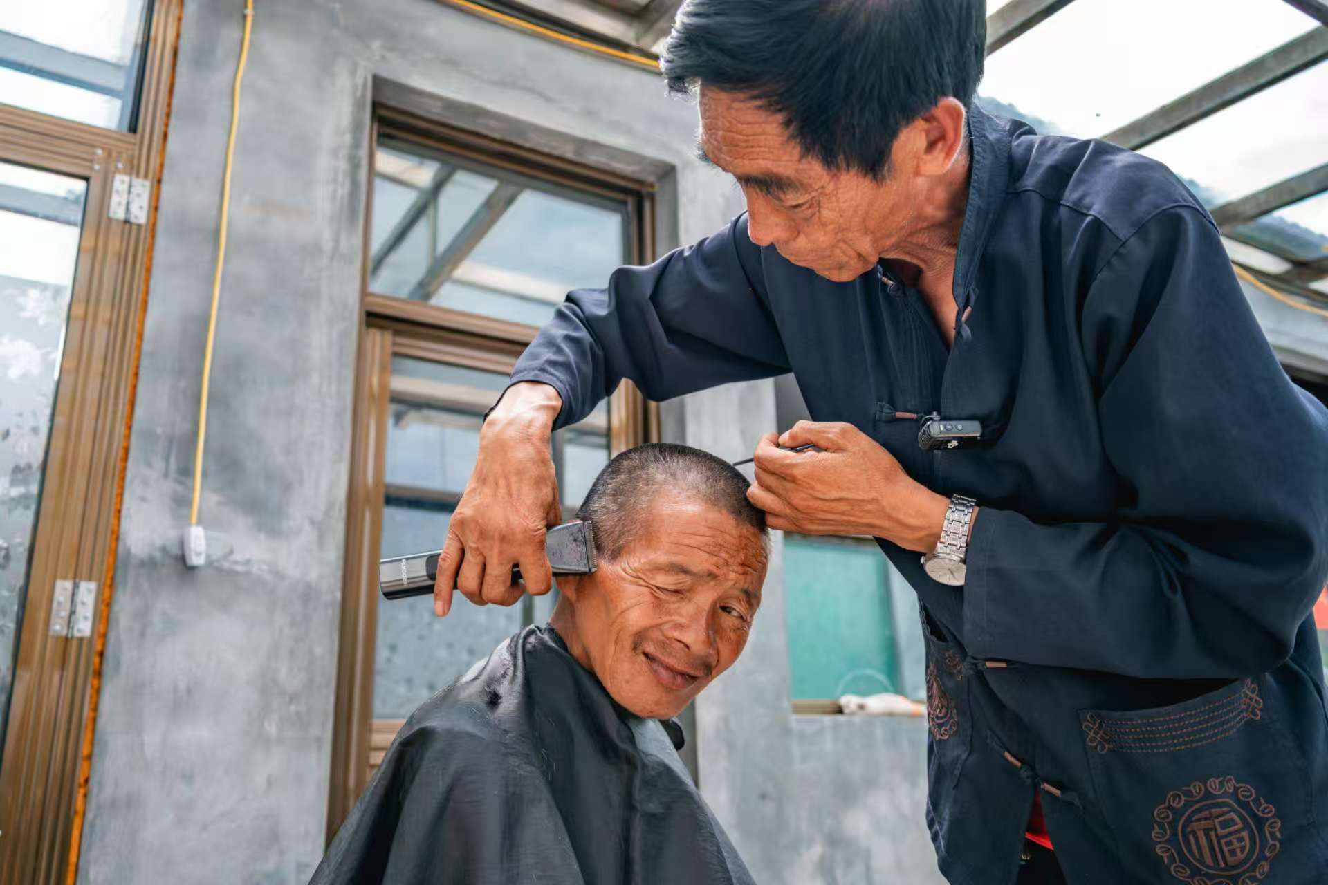桑建國正給秦海松理發。